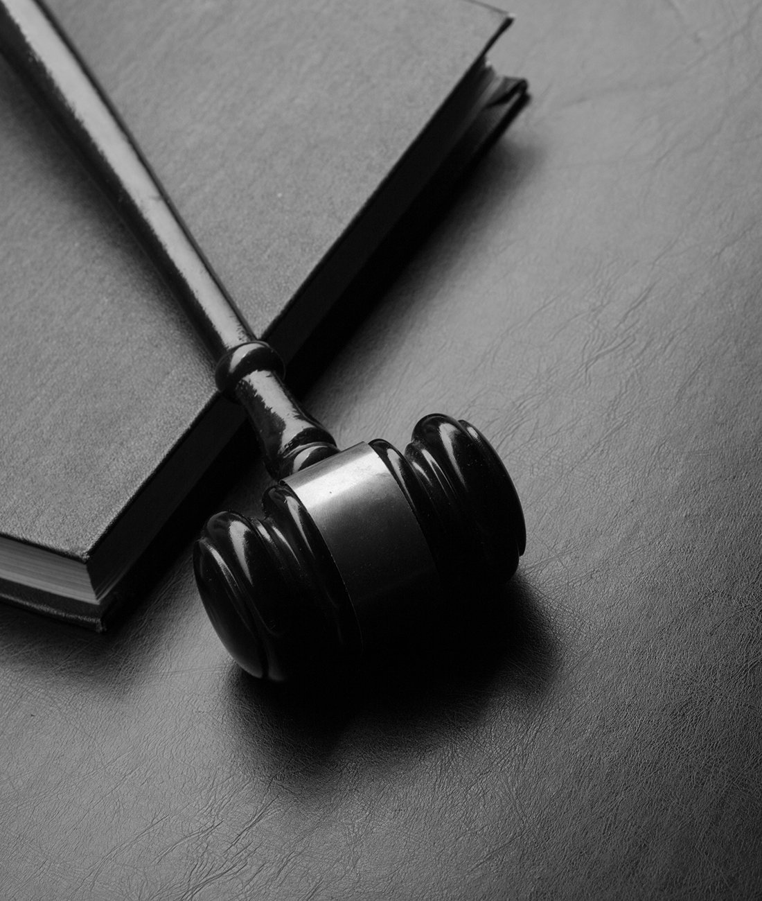 Maillet de juge posé sur un bureau avec un livre de droit.